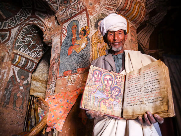 Man holding ancient Ethiopian gospel book from 5th century - image by Kanokwann/shutterstock.com